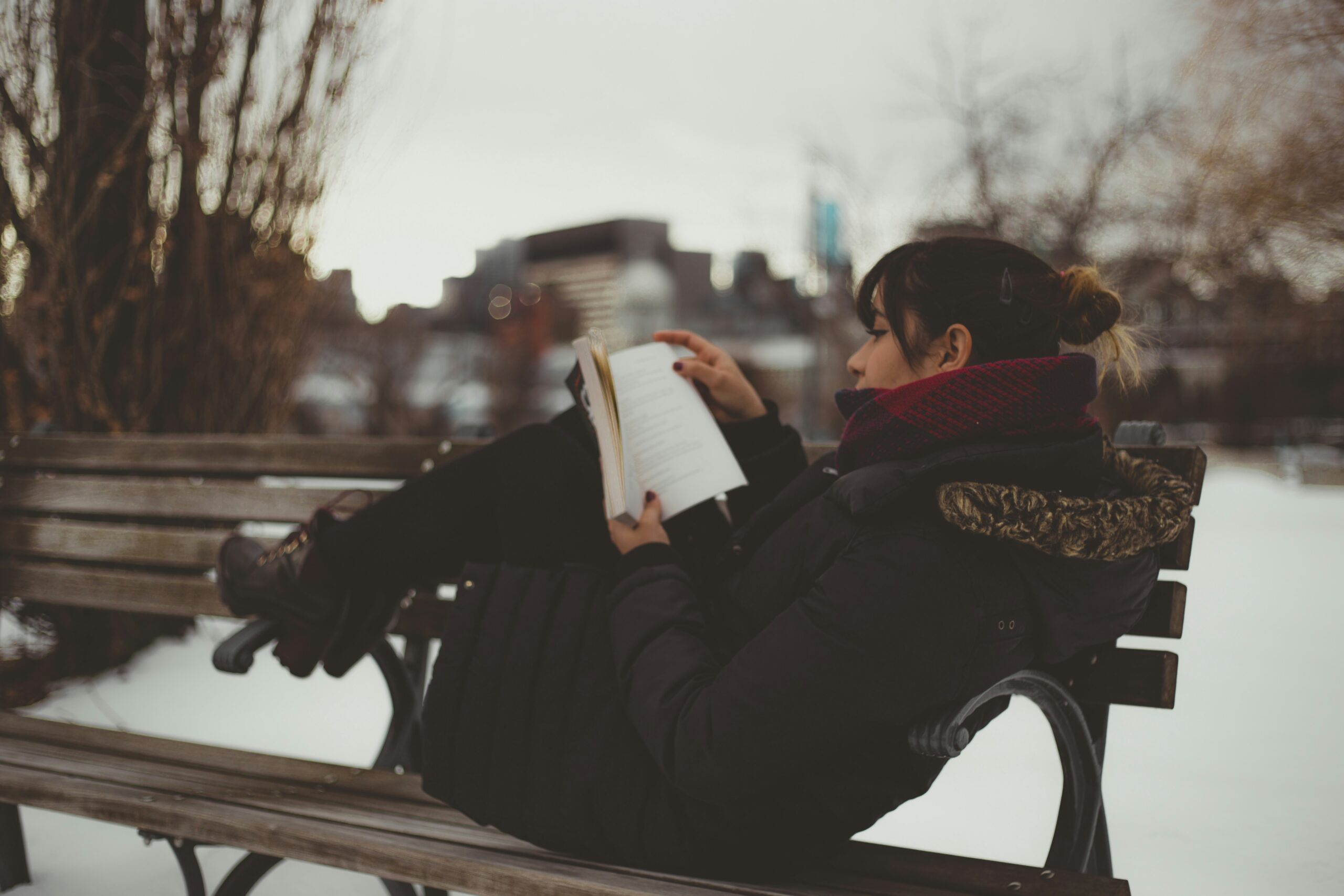Person reading a book in winter outdoors